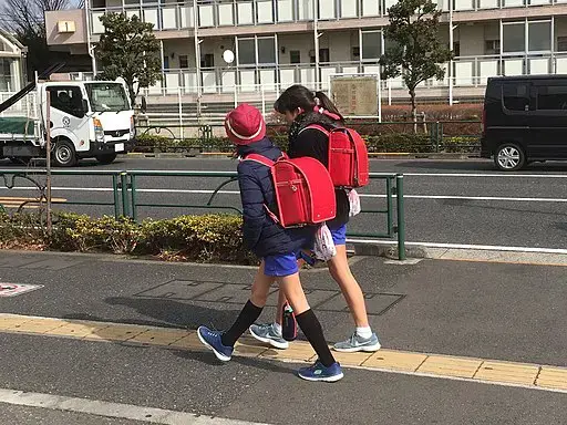 Niños de la escuela japonesa llevando randoseru